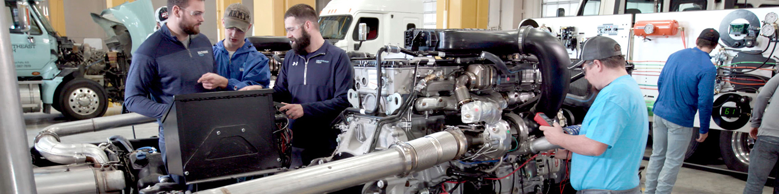 Students planning repair on large diesel engine in diesel lab