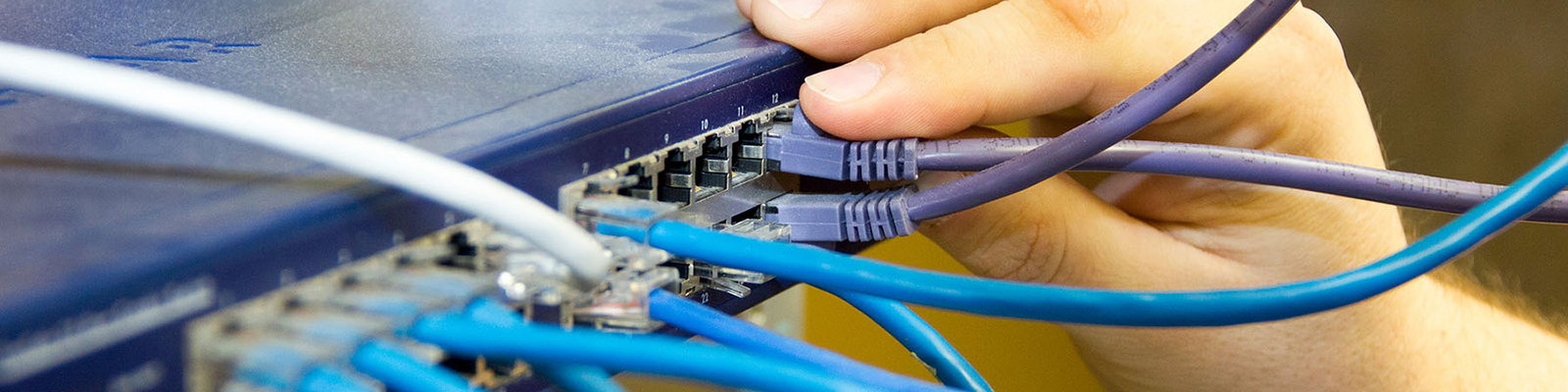 Computer server with multiple cords, hand plugging a cord in