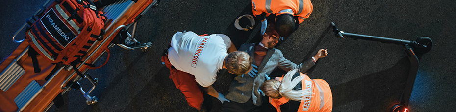 Paramedics giving treatment to person laying on the ground