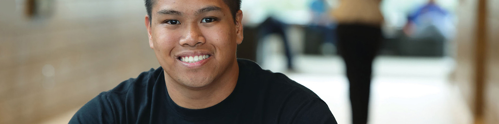 Smiling male student at a study table at Southeast Tech with an open binder in front of him