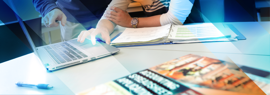 Student in classroom pointing to laptop screen