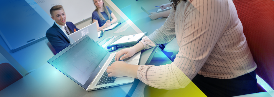 Student in classroom pointing to laptop screen