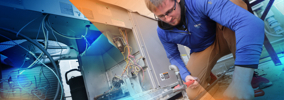 Student kneeling with wrench beside open AC unit