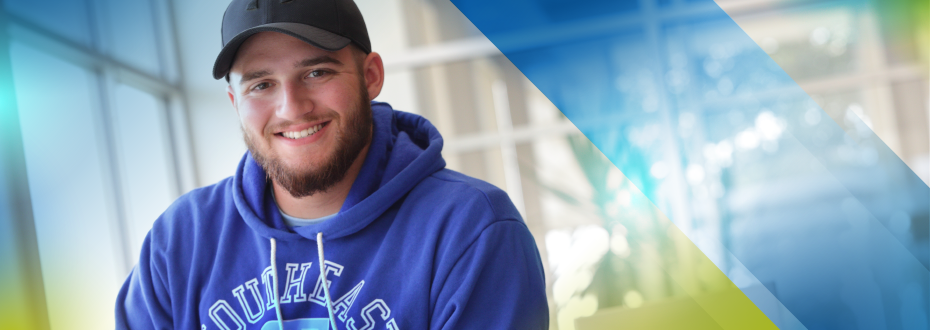 Smiling male student at a study table at Southeast Tech with an open binder in front of him
